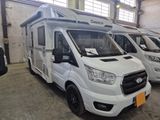 trois camping-cars blancs garés en rangée dans un garage