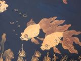 two gold fish swimming in a pond of water