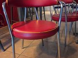 Plusieurs chaises rouges sont alignées en rangée dans un restaurant