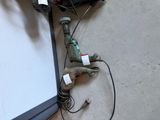 a drill and some wires on the floor next to a laptop