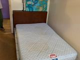 un homme debout près d'un lit dans une chambre