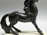 statue of a black horse on a marble base