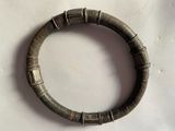 une photo d'un bracelet posé sur une surface blanche