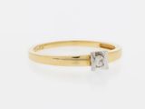 a yellow gold ring with a single diamond in the center