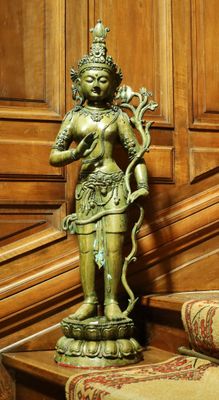 une statue représentant une femme tenant un serpent sur une table