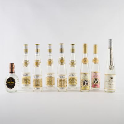 plusieurs bouteilles d'alcool sont alignées sur une surface blanche