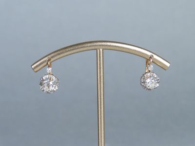 a close up of a pair of earrings on a stand