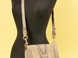 un gros plan sur le torse d'un mannequin sur lequel est posé un sac à main