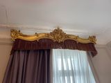 a curtain with a gold trim hanging on the wall