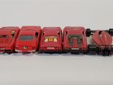 several toy cars are lined up in a row on a white surface