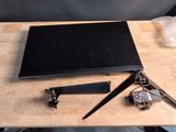 un ordinateur portable posé sur une table en bois, à côté d'une paire de ciseaux
