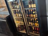 a refrigerator with a lot of bottles of beer inside of it