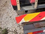 a red truck with yellow and red stripes parked on the side of the road