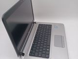 a silver laptop with a black keyboard on a white surface