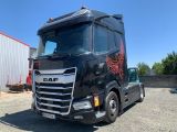 un gros camion noir garé sur un parking