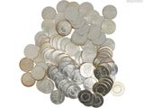 un tas d'argent et de pièces d'argent posé sur une surface blanche