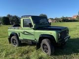 une photo d'un Land Rover vert garé dans un champ