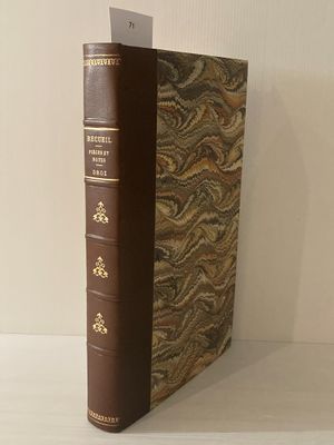 un vieux livre posé sur une table blanche à côté d'un mur blanc