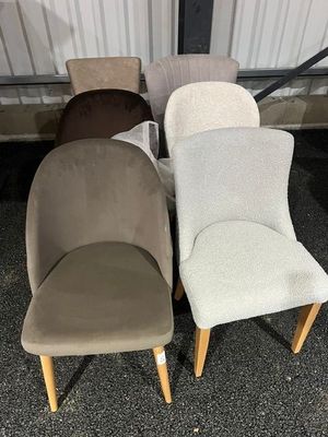 trois chaises de couleurs et de tailles différentes, disposées devant un bâtiment