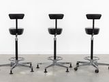 three black stools sitting on top of each other in a room