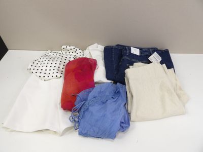 a white table topped with lots of clothes on it