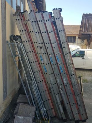 a stack of ladders leaning against a building