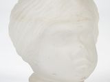 a white vase with a face on it on a white surface
