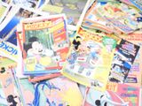 a pile of magazines on the floor with mickey mouse on them