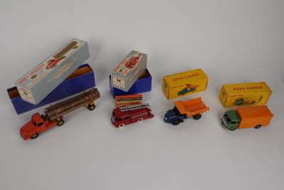 several toy trucks are lined up in a row on a white surface