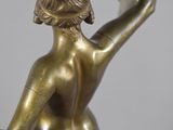 bronze statue of a woman holding a flower in her right hand