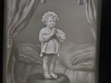 a black and white photo of a child on a bed