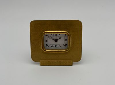 une image représentant une horloge dorée avec des chiffres romains sur fond blanc