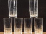 four shot glasses sitting on top of a wooden table next to each other