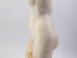 marble statue of a woman sitting on a block with a hood on her head