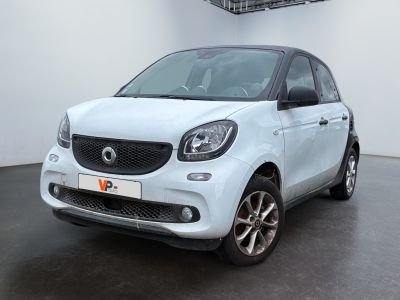 La Smart est garée dans une pièce blanche au sol noir.