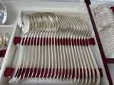 silverware in a box with red handles and spoons on a table