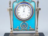 une horloge posée sur un support sur une table