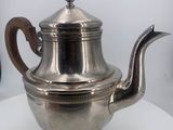 a silver tea pot sitting on a white table