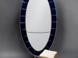 an oval mirror with a bench in front of it
