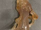 a glass figurine of a woman holding a vase