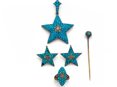 trois broches en forme d'étoile de couleur turquoise et une allumette posées sur une surface blanche