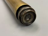 an old brass telescope with a metal case on a white surface