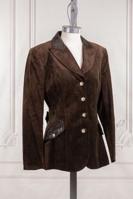 une veste marron posée sur un mannequin devant un mur blanc