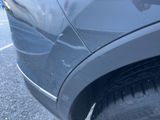 a close up of a car ' s tire with a person ' s hand on it