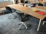 a table with chairs and a laptop on it in an office