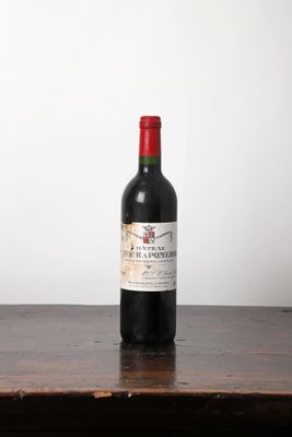 une bouteille de vin rouge posée sur une table en bois