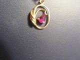 un collier en or orné d'une pierre rose