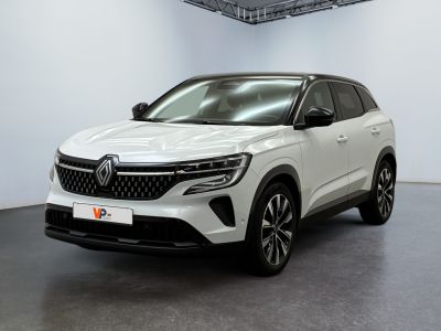 Une voiture blanche est garée dans une grande pièce au sol noir.