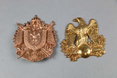 two gold colored metal badges with eagle and shield on them