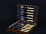 a wooden case with a set of knives and knives in it